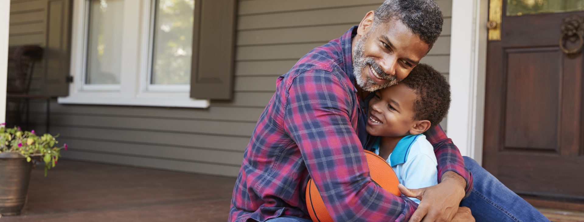 Father And Son Discussing Basketball On Porch Of Home