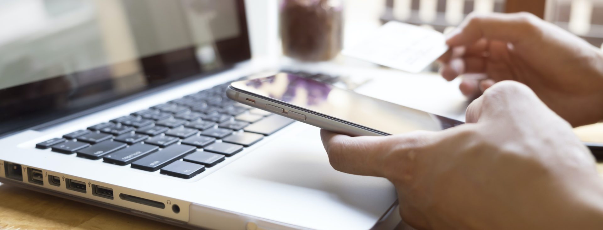 Woman using laptop and mobile phone to online shopping and pay by credit card. Mobile focus. Vintage tone, Retro filter effect, Soft focus, Low light.(selective focus)