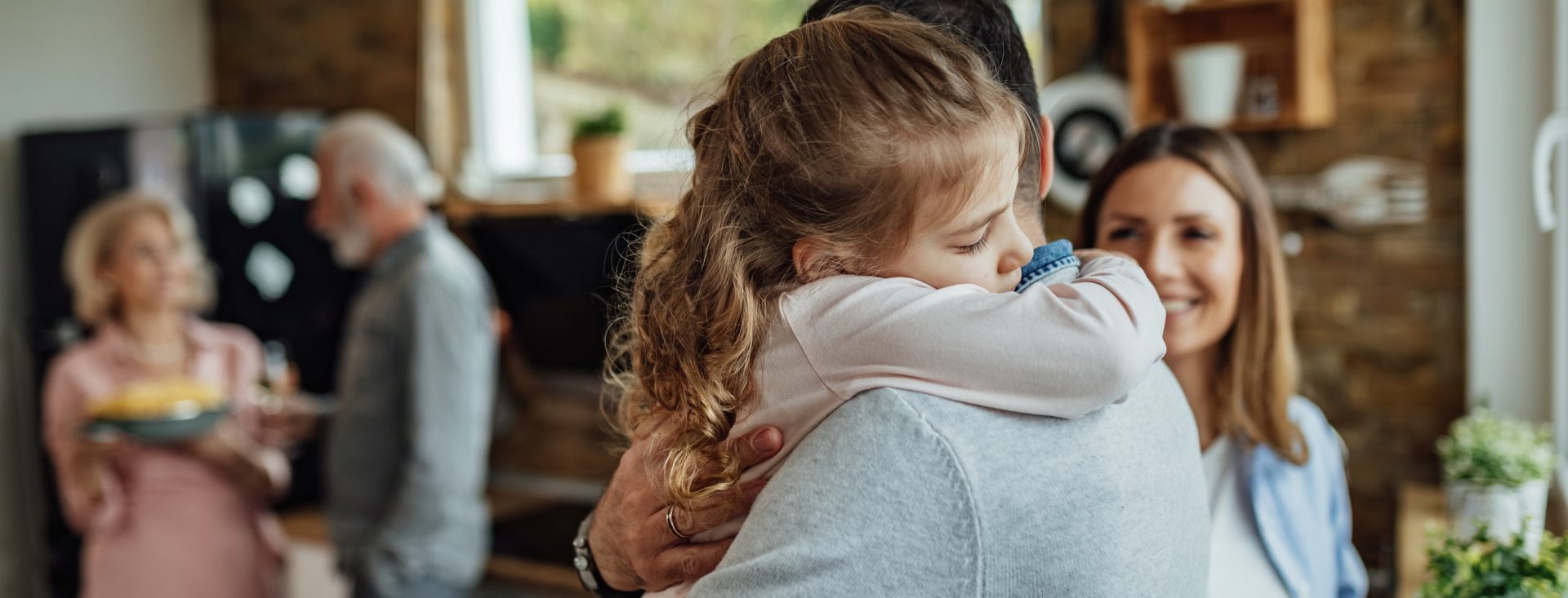 Affectionate daughter embracing her father with eyes closed.